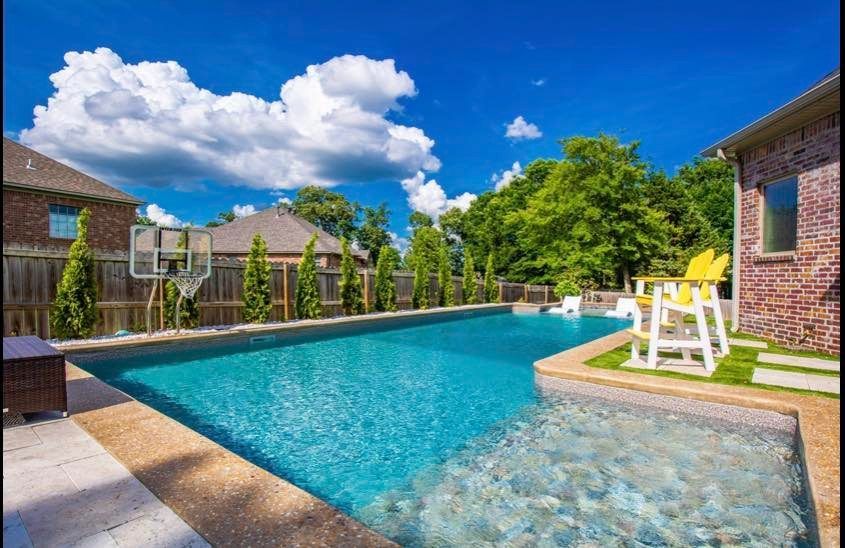 A large swimming pool in the backyard of a house