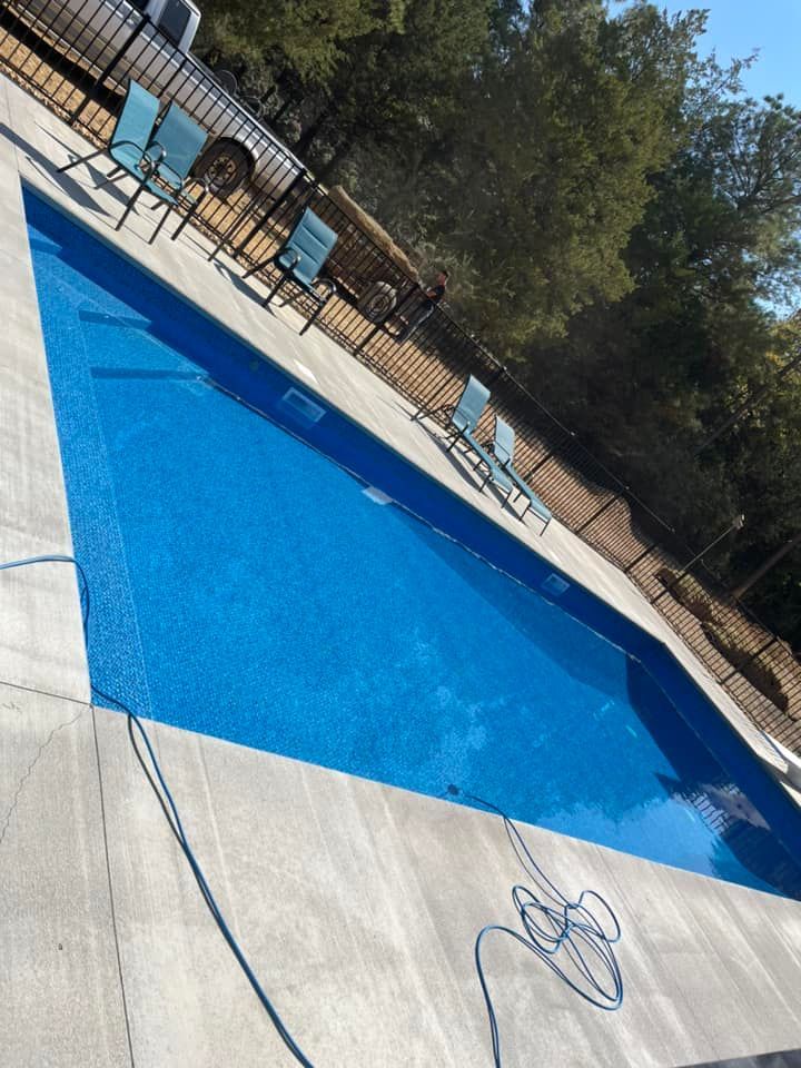A large swimming pool with chairs and a truck in the background