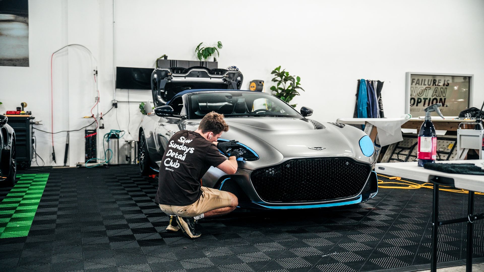 A man is working on a car in a garage.