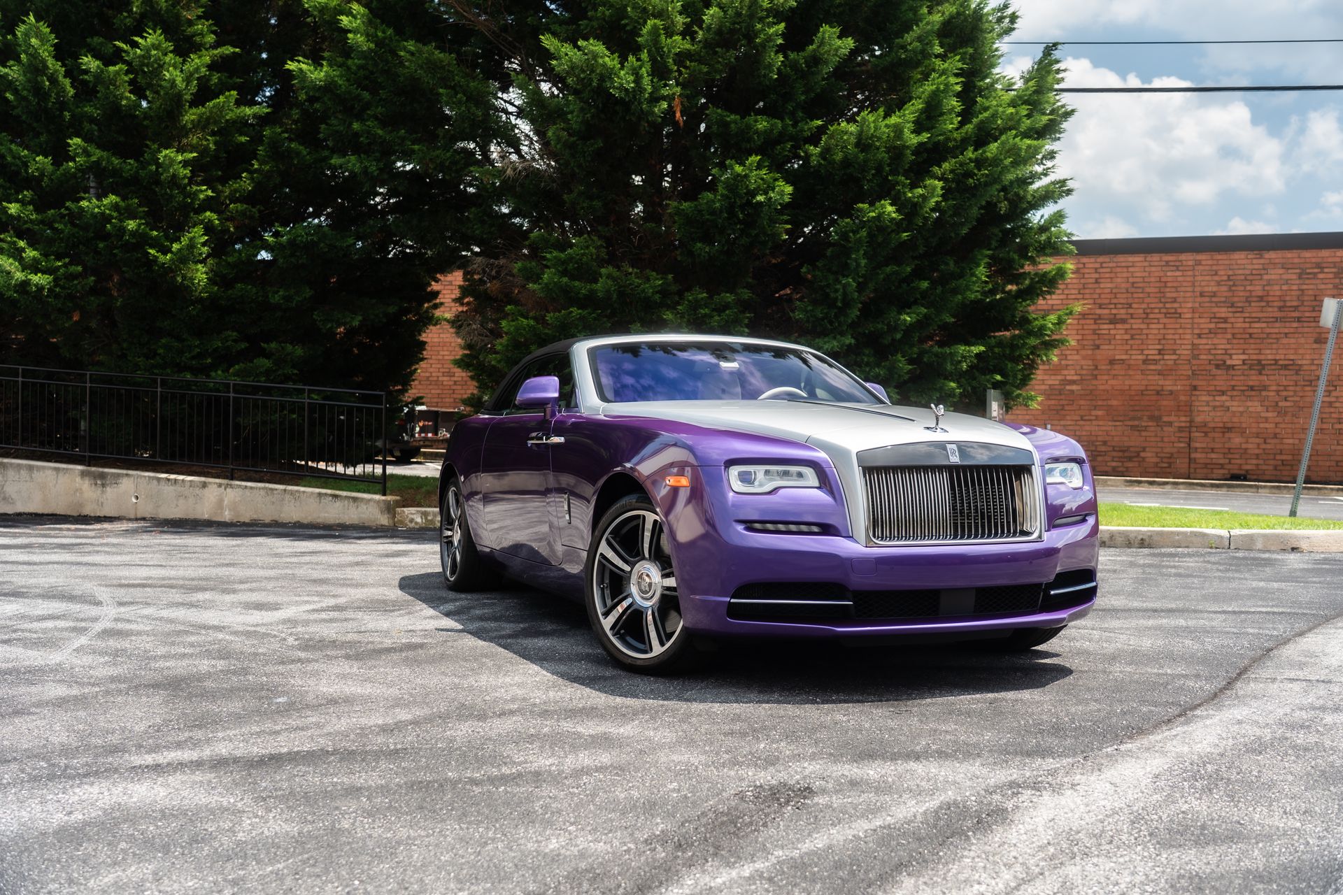 Purple and silver Rolls Royce parked outside, sunny day.