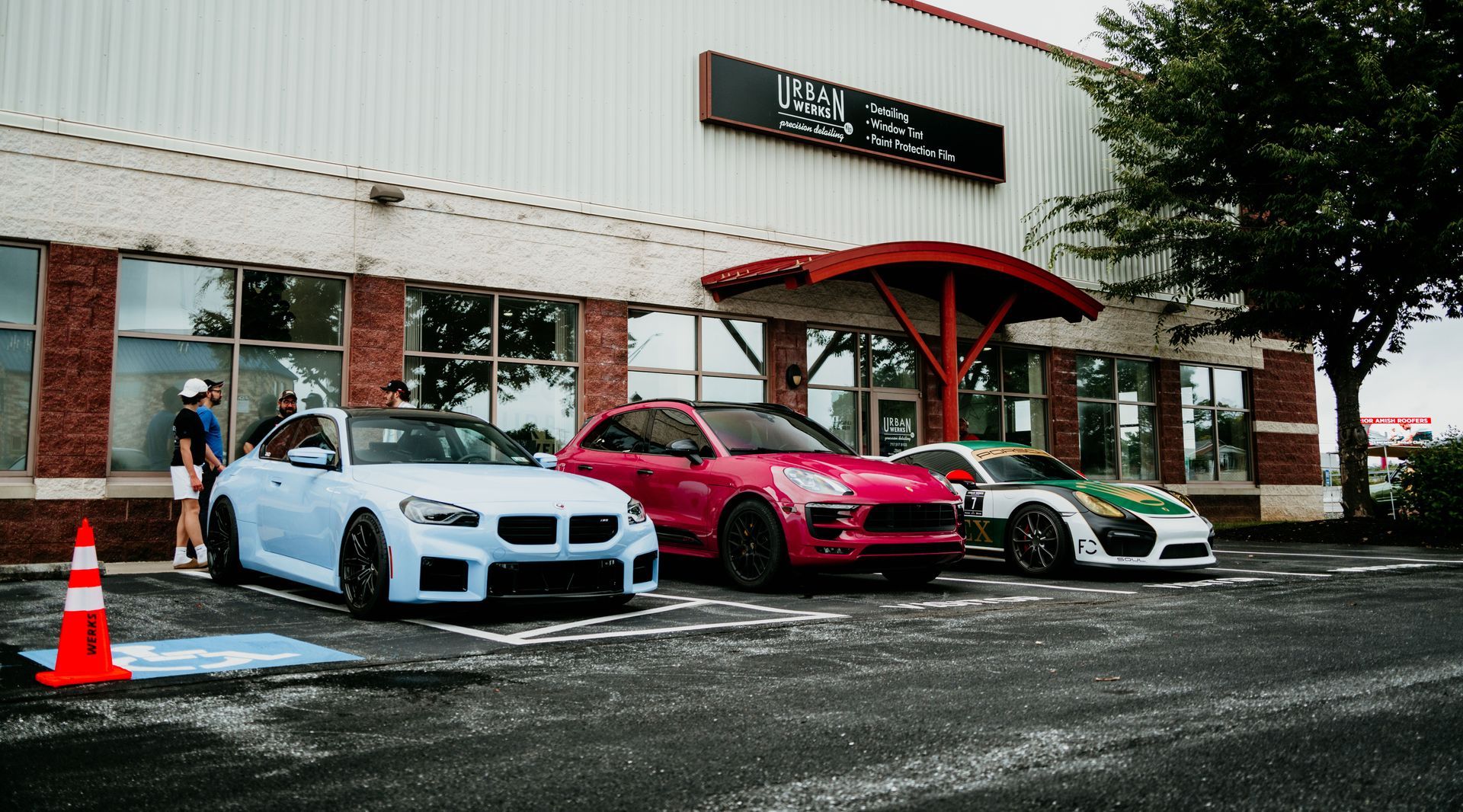 Three colorful sports cars parked outside a building.
