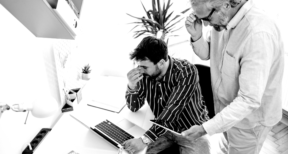 Manager micromanaging an uneasy employee, illustrating the negative impacts of micromanagement.