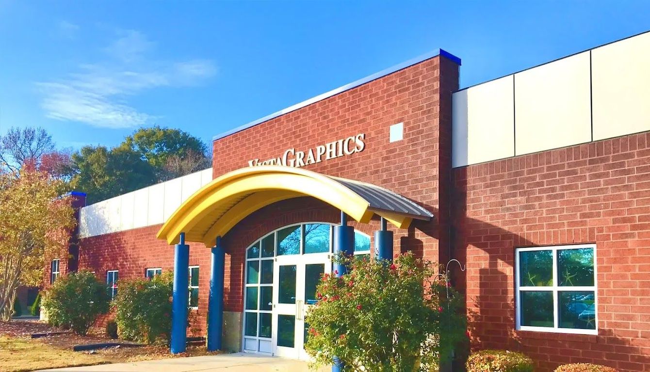 A red brick building featuring a bright yellow arched entrance, large windows, and signage reading 