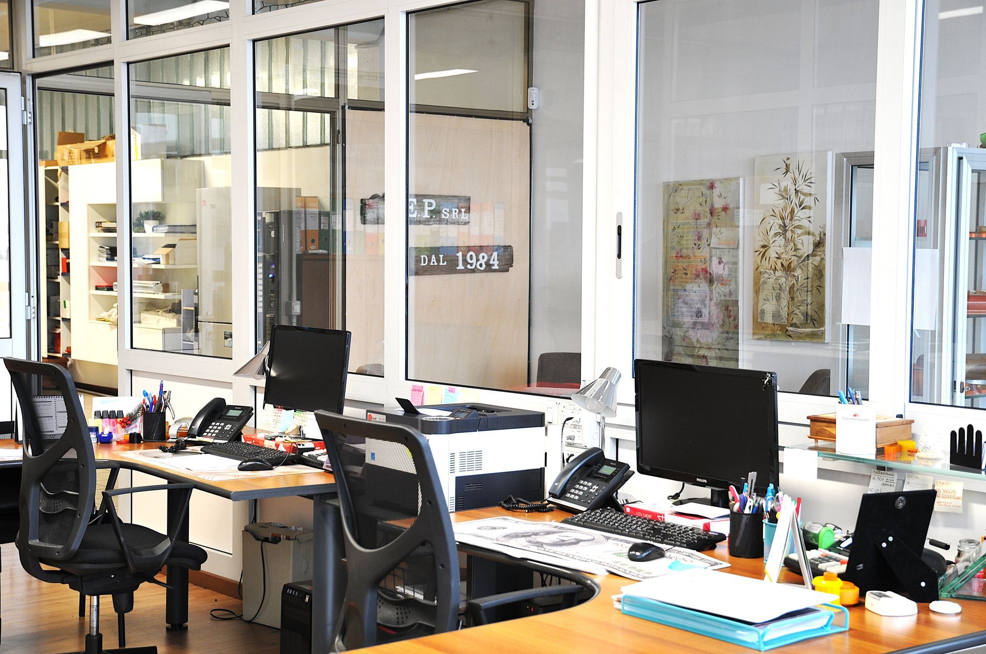 Un ufficio con tante finestre, scrivanie e sedie
