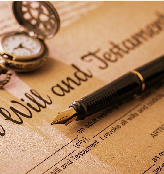 Will and testament document with fountain pen and pocket watch on a wooden desk