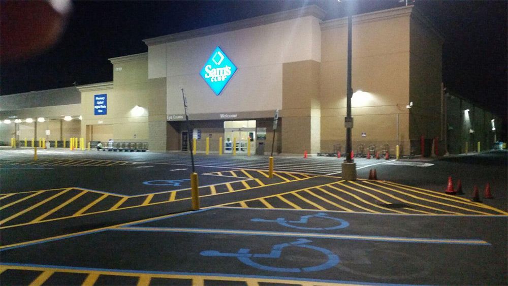 Walmart store entrance at night with lit parking lot and blue accessible parking markings