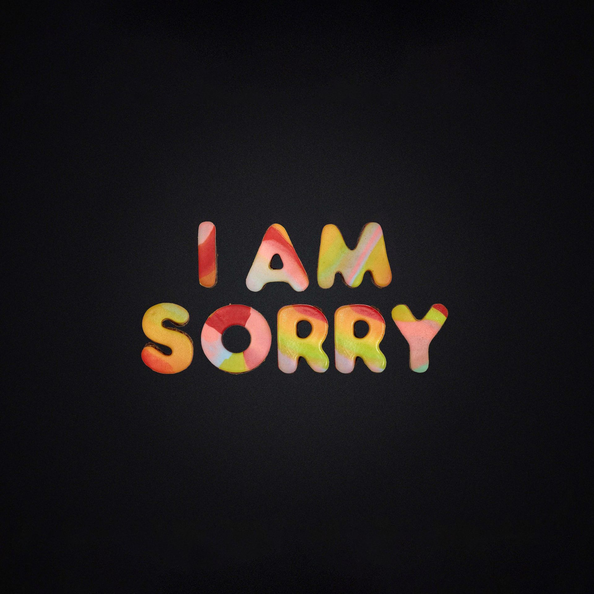 A black background with colorful letters that say i am sorry