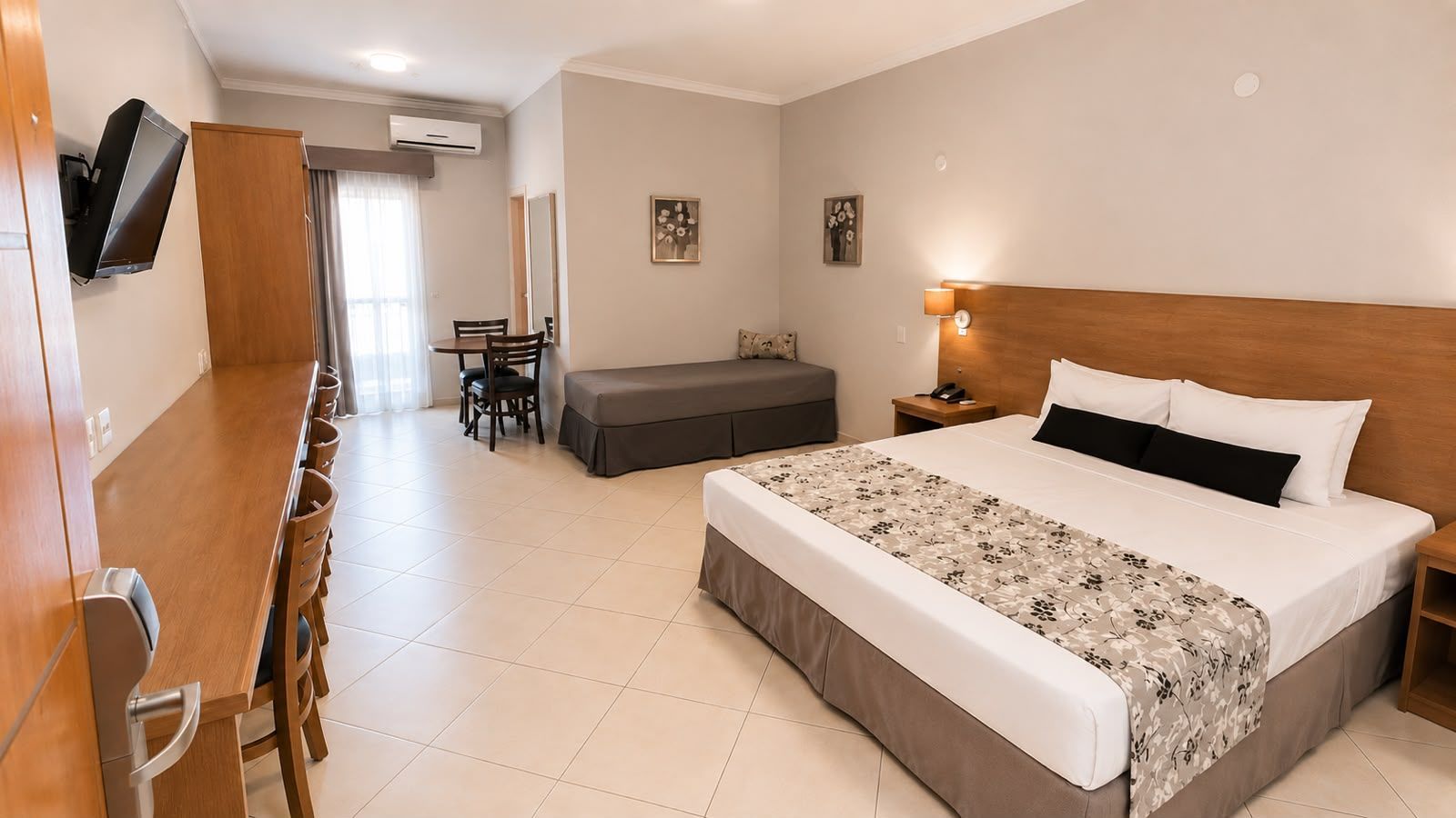 quarto com uma cama king e cesta de café da manha, ao lado uma mesa com cadeira
