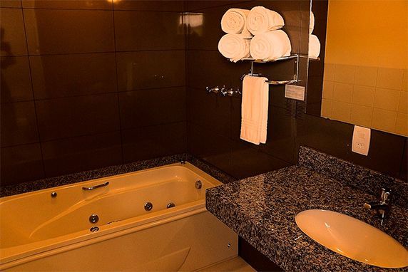 banheiro todo equipado com toalhas, banheira e produtos de higiene