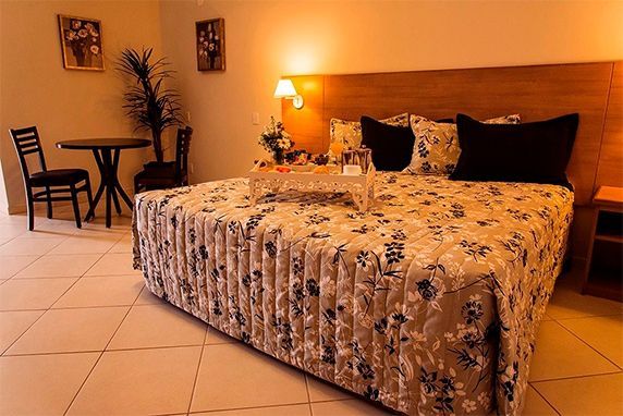 quarto com uma cama king, cesta de café da manhã, mesa e cadeiras