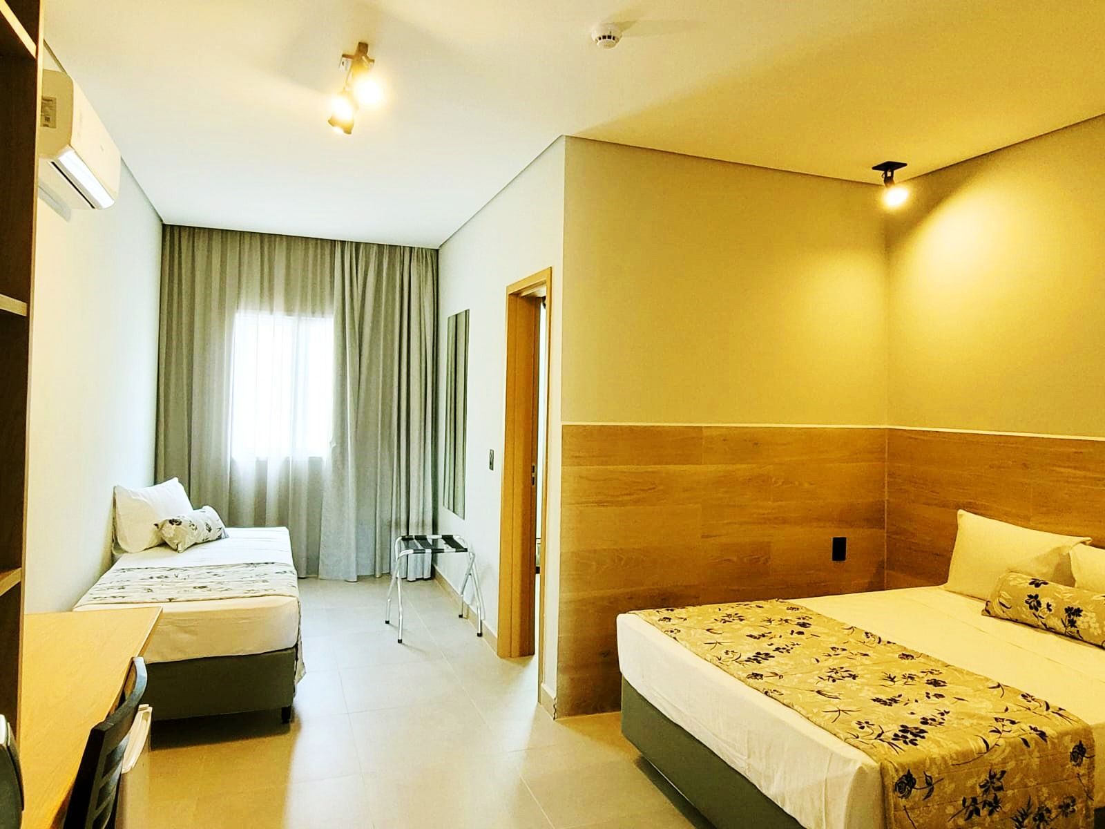 quarto luxo com cama de casal, cortinas, ar condicionado, mesa de trabalho