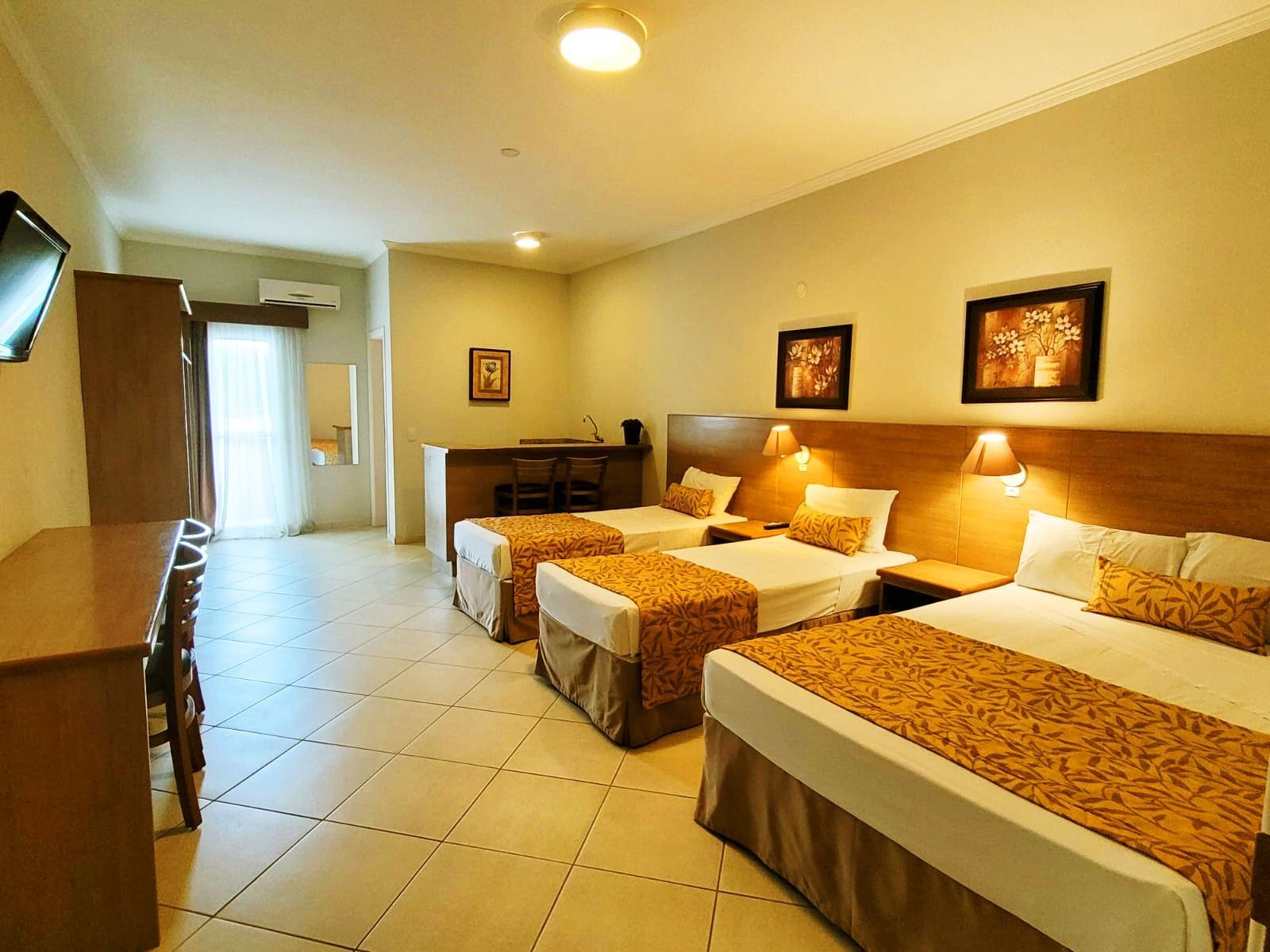 quarto luxo com 2 camas de solteiro e uma de casal