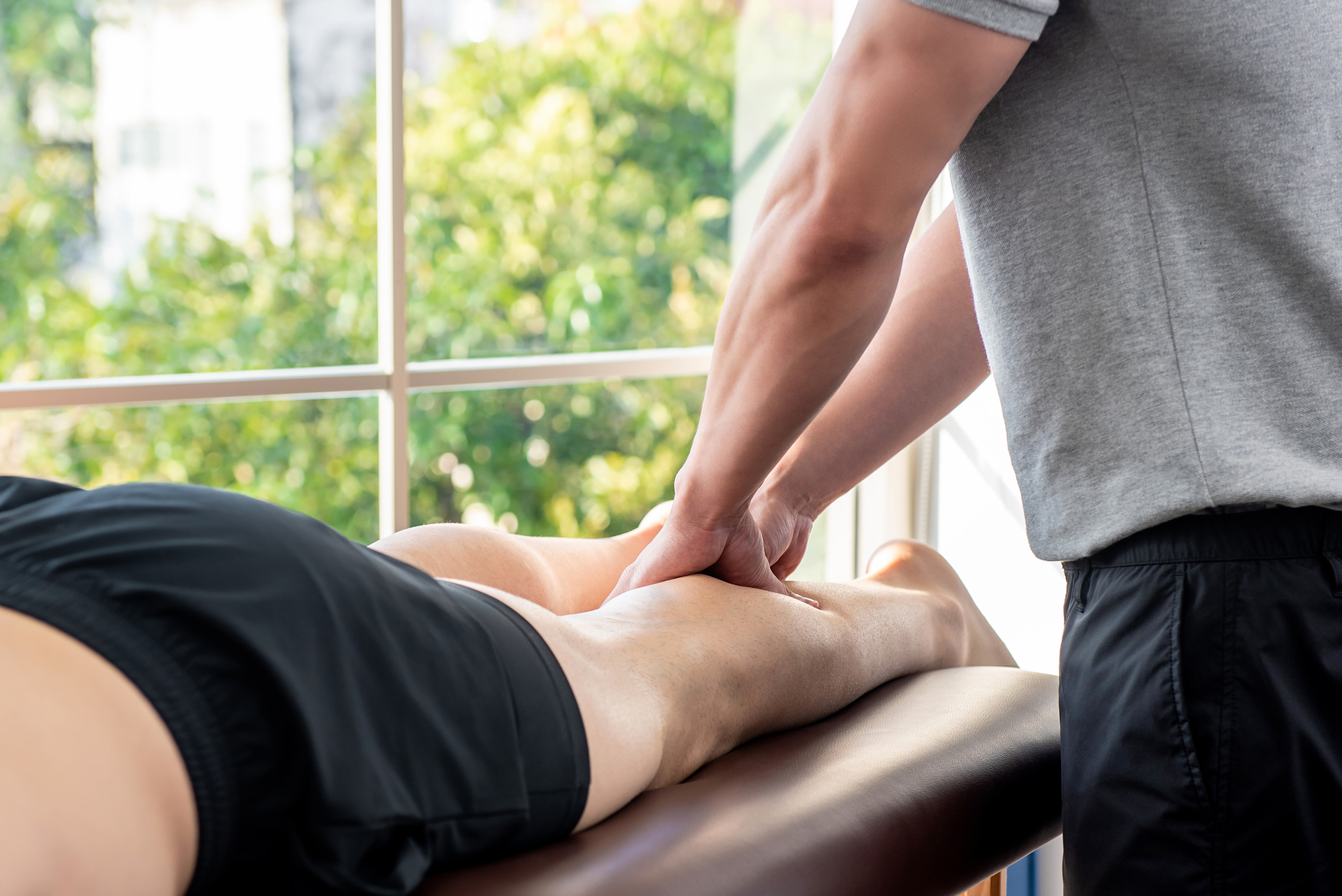 Person receiving leg massage from a therapist.