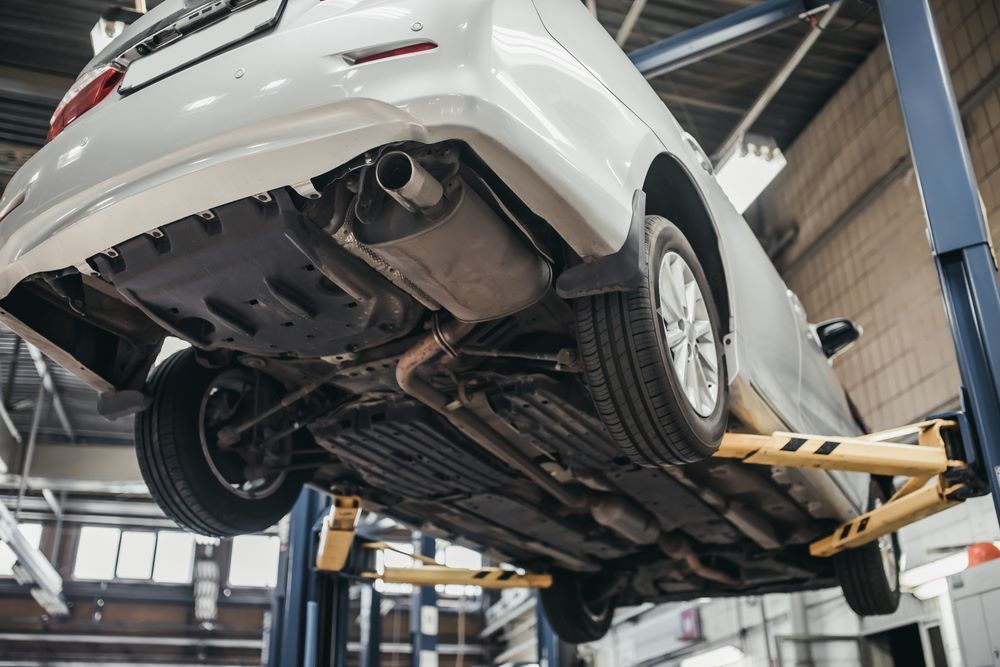 A Car is Sitting on a Lift in a Garage — Sprint Mufflers, Exhausts & Mechanical Repairs in Stuart, NT