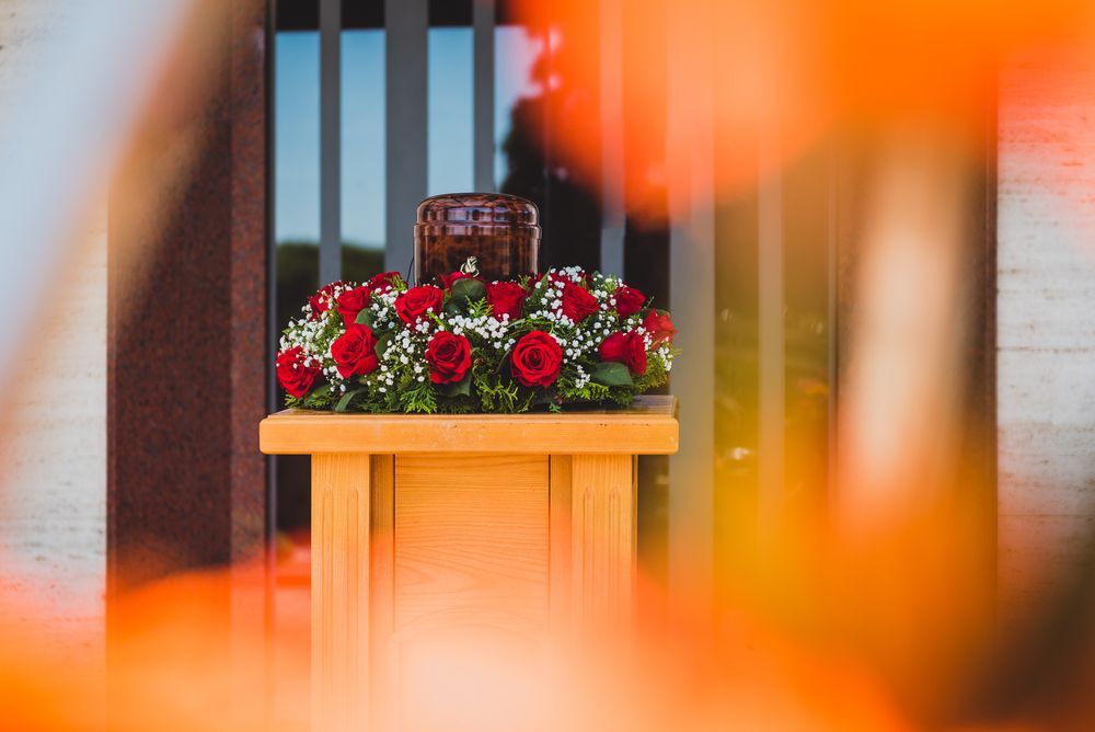 A Wooden Podium With Red Roses And Urn — Territory Funerals In Yarrawonga, NT