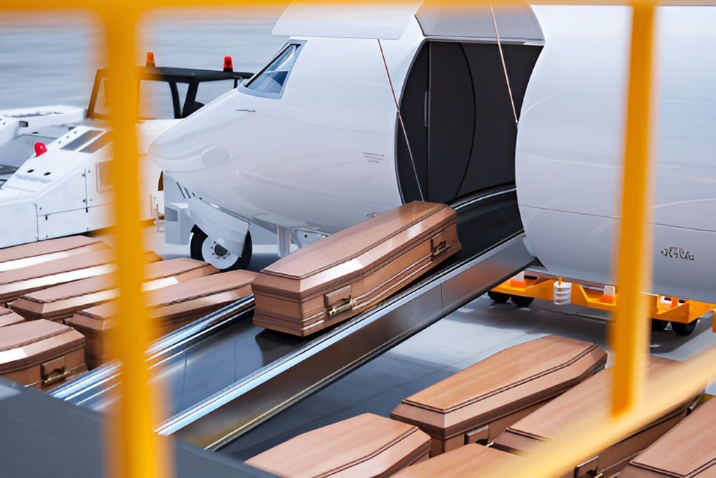 A Bunch of Coffins Are Sitting on a Conveyor Belt Next to an Airplane — Territory Funerals In Yarrawonga, NT