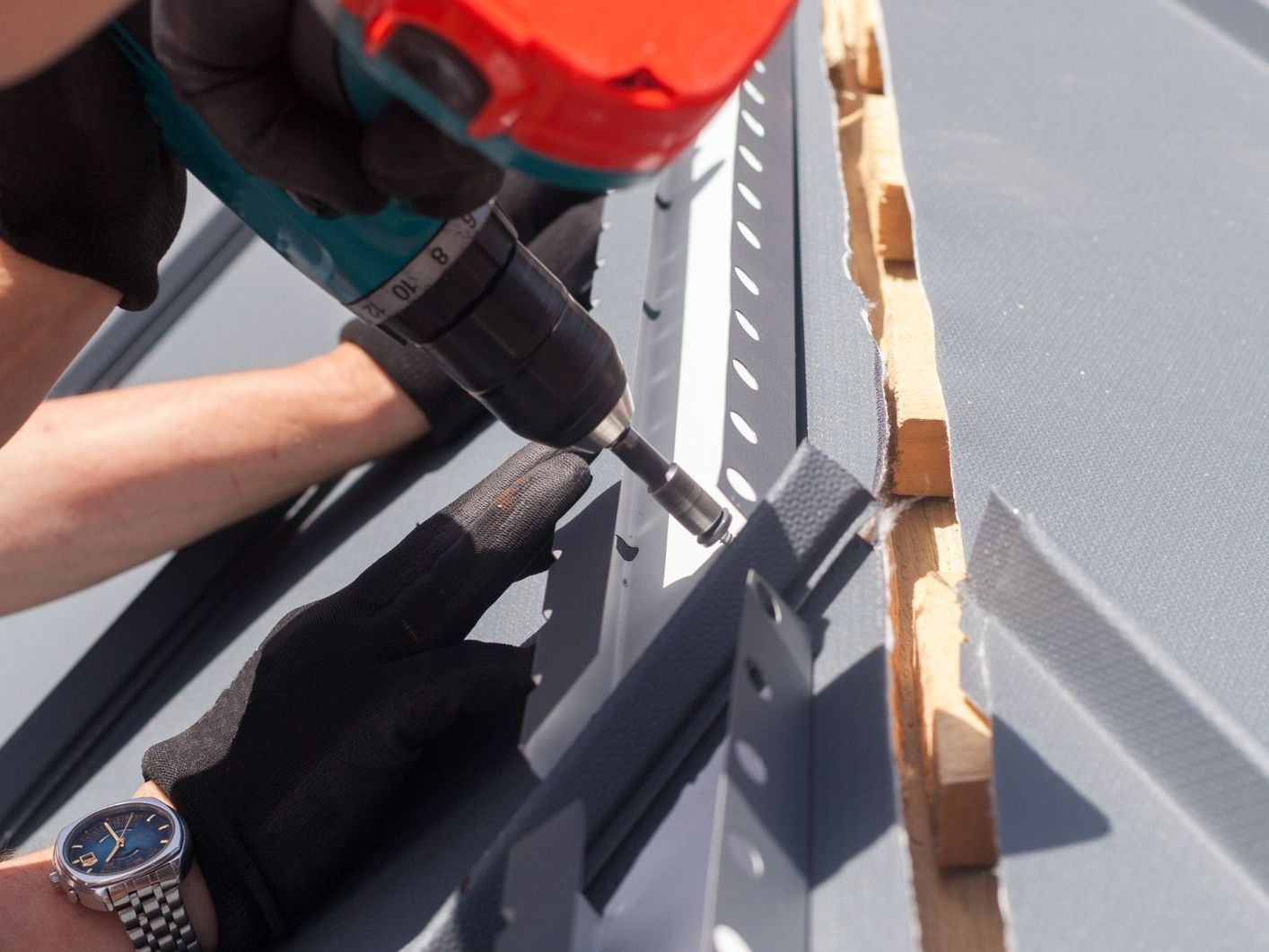 A man wearing a watch is working with a drill