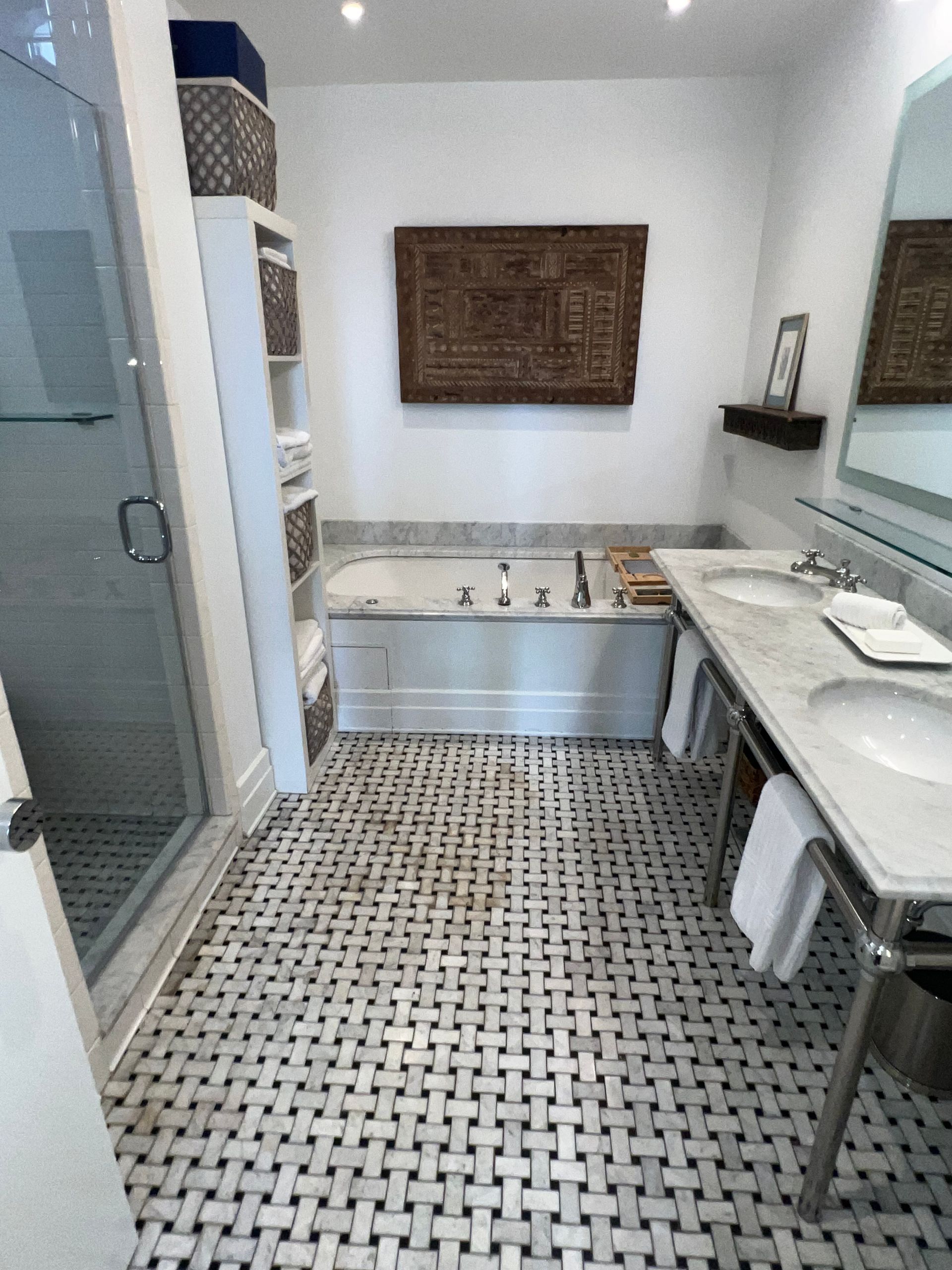 Modern bathroom with mosaic tile floor, bathtub, shower, sink, and wall mirror