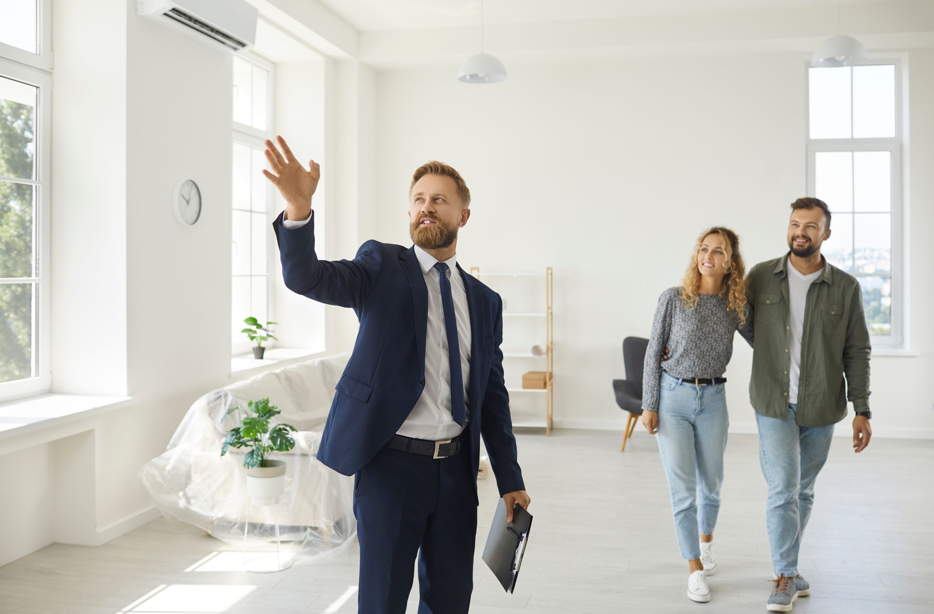 Real estate agent showing a bright empty apartment to two clients