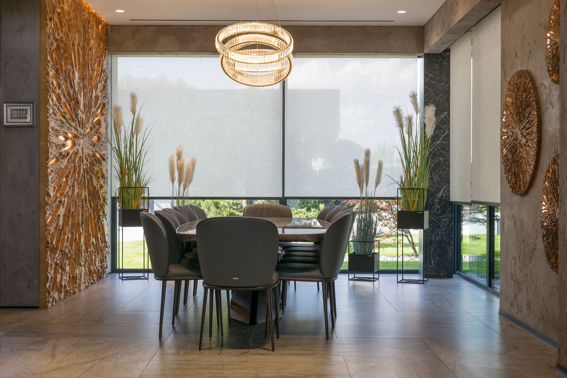 Modern dining room with large windows, round table, dark chairs, and decorative wall art