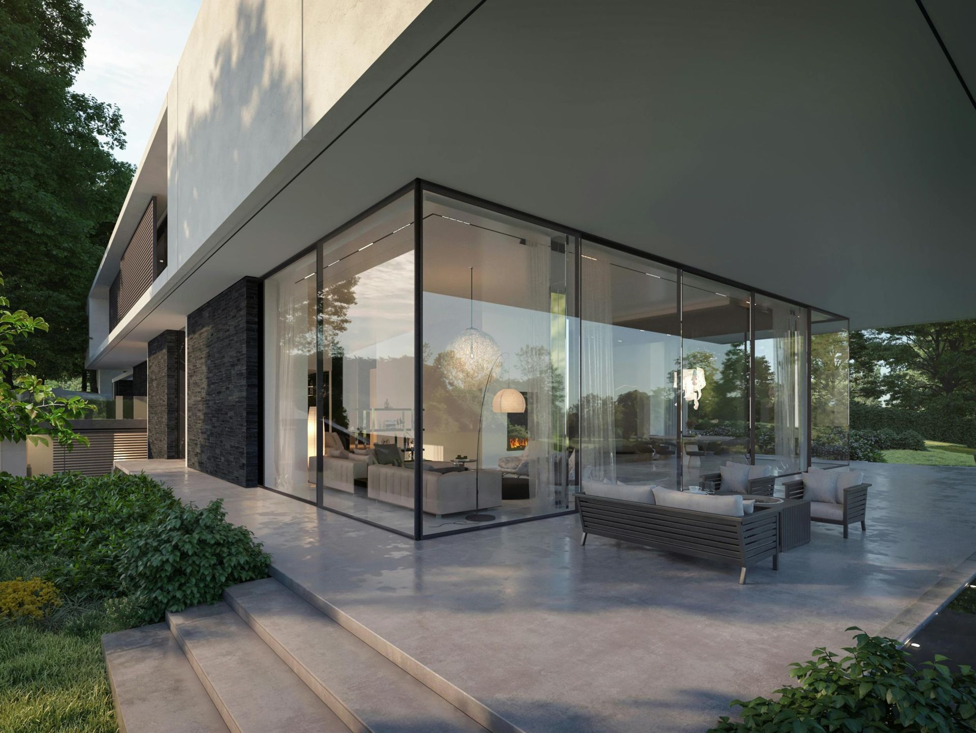 Modern glass-fronted house patio with outdoor seating and surrounding greenery