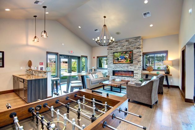 a living room with a couch , chairs , tables and a chandelier .