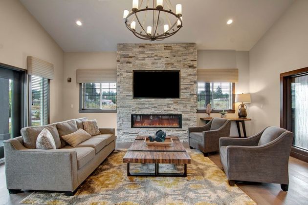 a living room with a couch , chairs , coffee table and television .