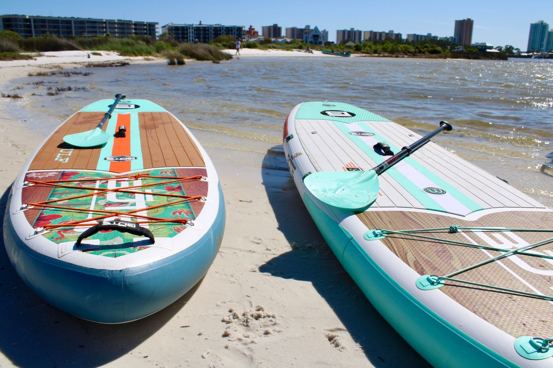 2 of our rental paddleboards sitting on a beach.