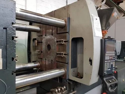 Macchina industriale per lo stampaggio a iniezione di materie plastiche con stampo aperto e pannello di controllo.
