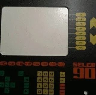 Pannello di gioco arcade retrò con un ampio trackpad, pulsanti e una tastiera con la scritta