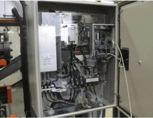 Armadio di controllo industriale aperto con cablaggio, relè e componenti elettrici all'interno.