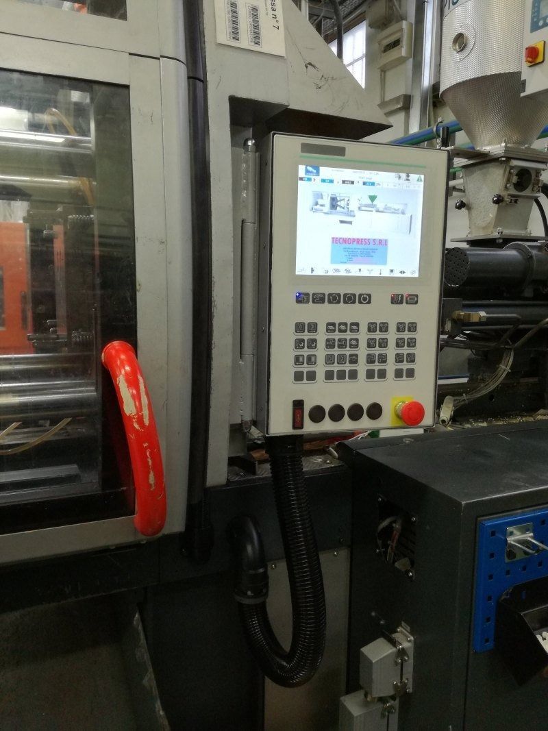 Pannello di controllo per macchinari industriali con display illuminato e pulsanti, montato a fianco del macchinario.