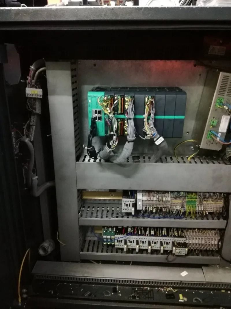 Armadio elettrico aperto con cablaggio, interruttori automatici e morsettiere all'interno di un involucro metallico.
