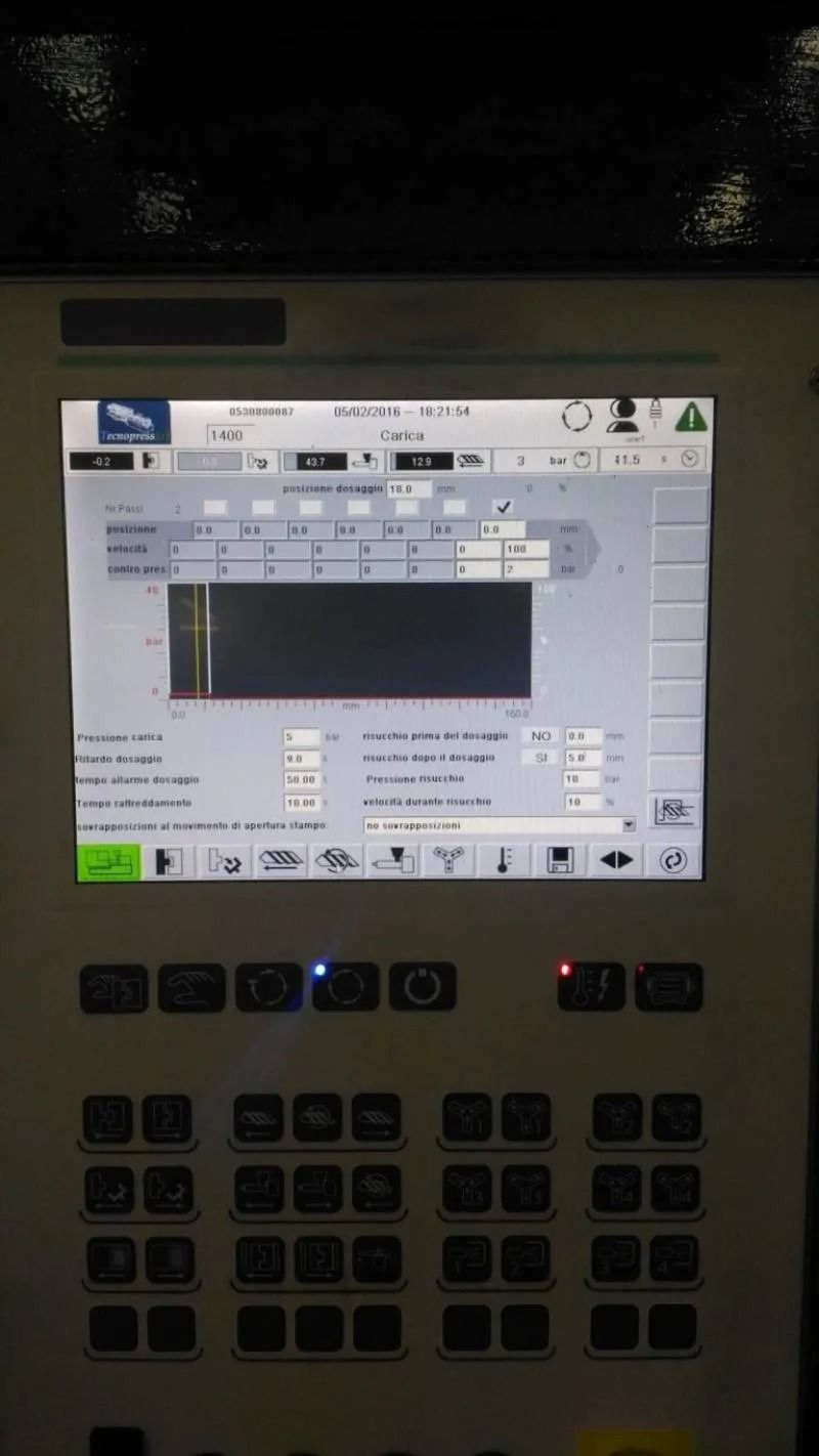 Pannello di controllo industriale con display touchscreen illuminato e pulsanti della tastiera sottostanti.