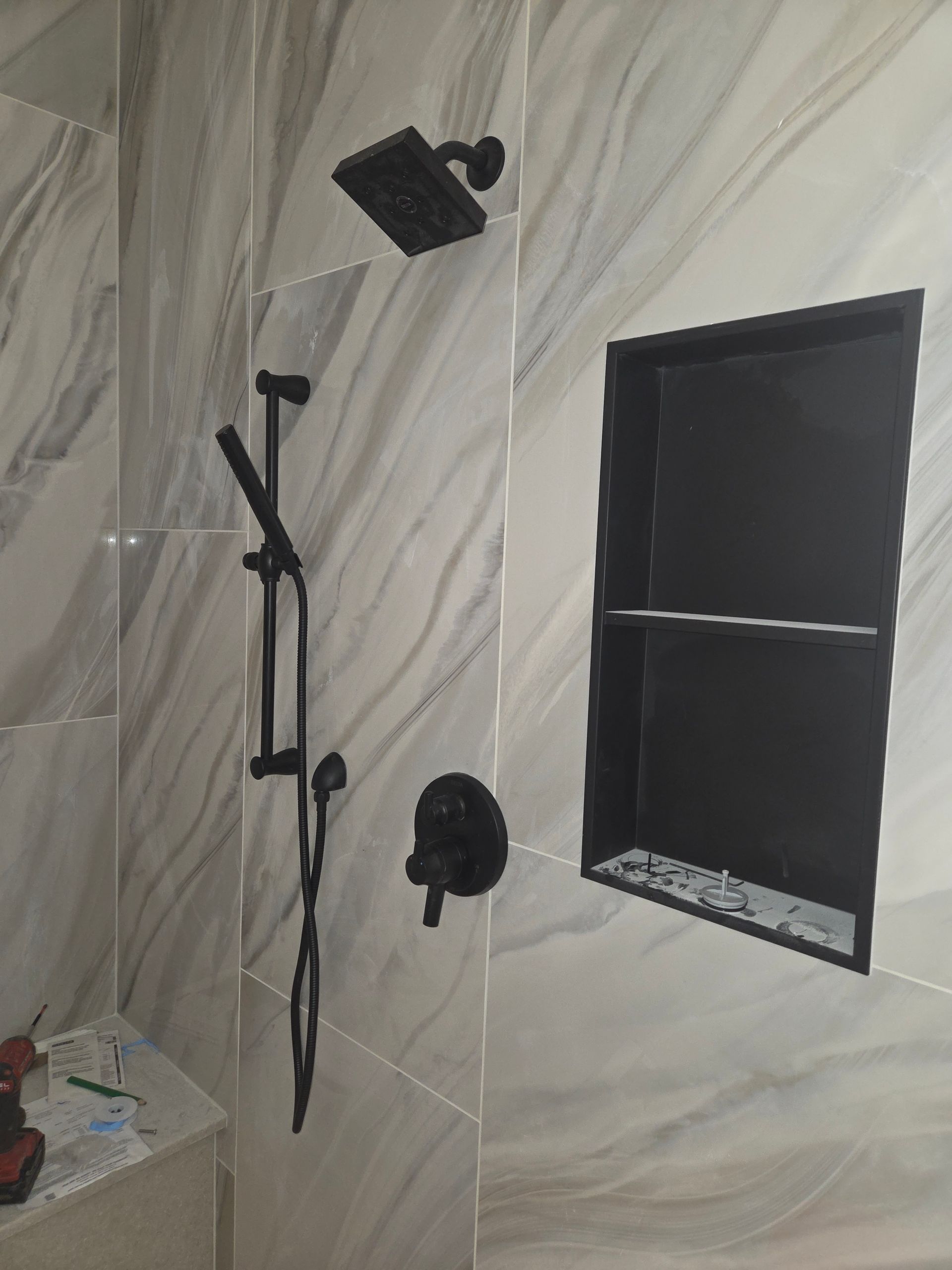 Interior room with marble-patterned walls, a black window, wall-mounted light, and a microphone stand.