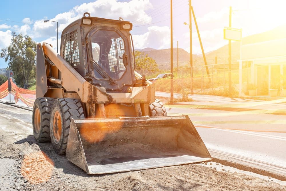 A Bulldozer Is Sitting On The Side Of A Road — D & M Tree Services In Taree, NSW