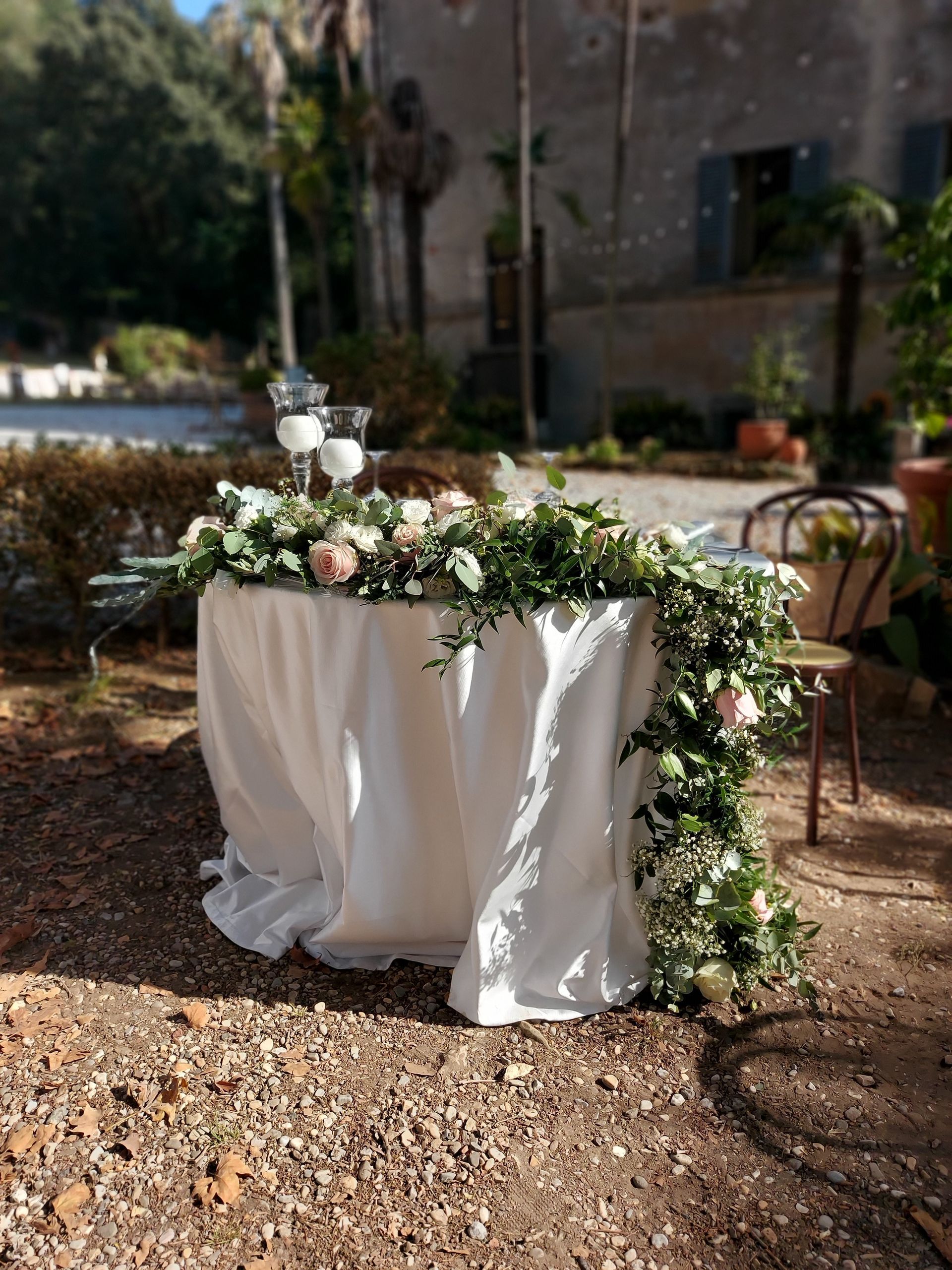 Un tavolo con una tovaglia bianca e dei fiori sopra.