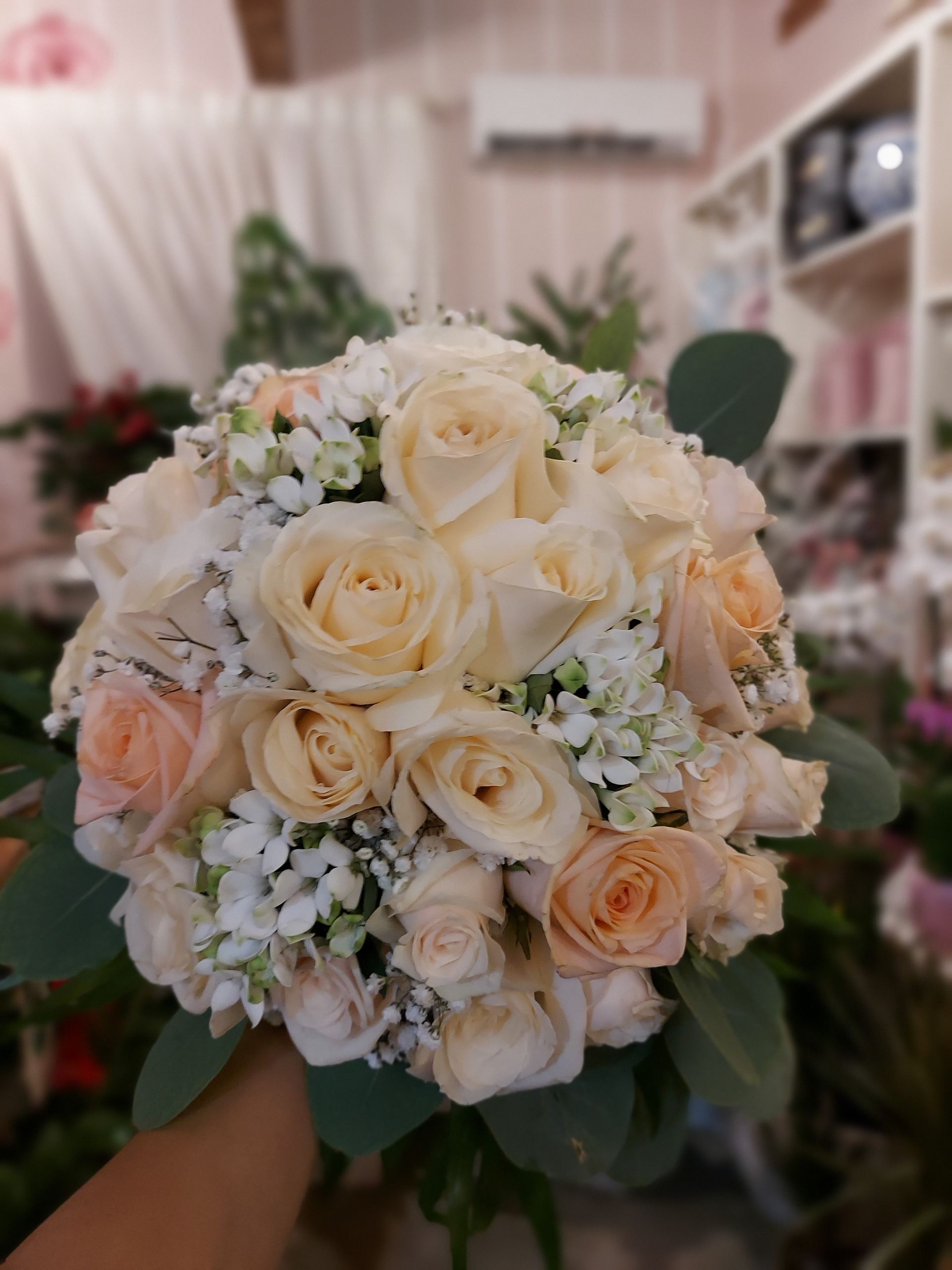 Una persona tiene in mano un mazzo di rose bianche e gypsophila