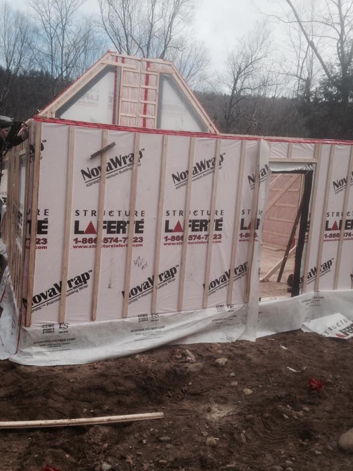 Un bâtiment à ossature bois partiellement construit, avec des panneaux d'isolation NovaWrap installés sur les murs extérieurs.