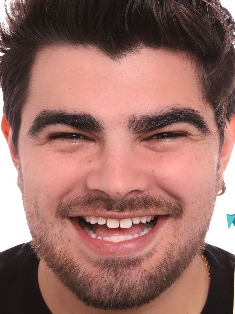 A close up of a man 's face with a beard smiling.