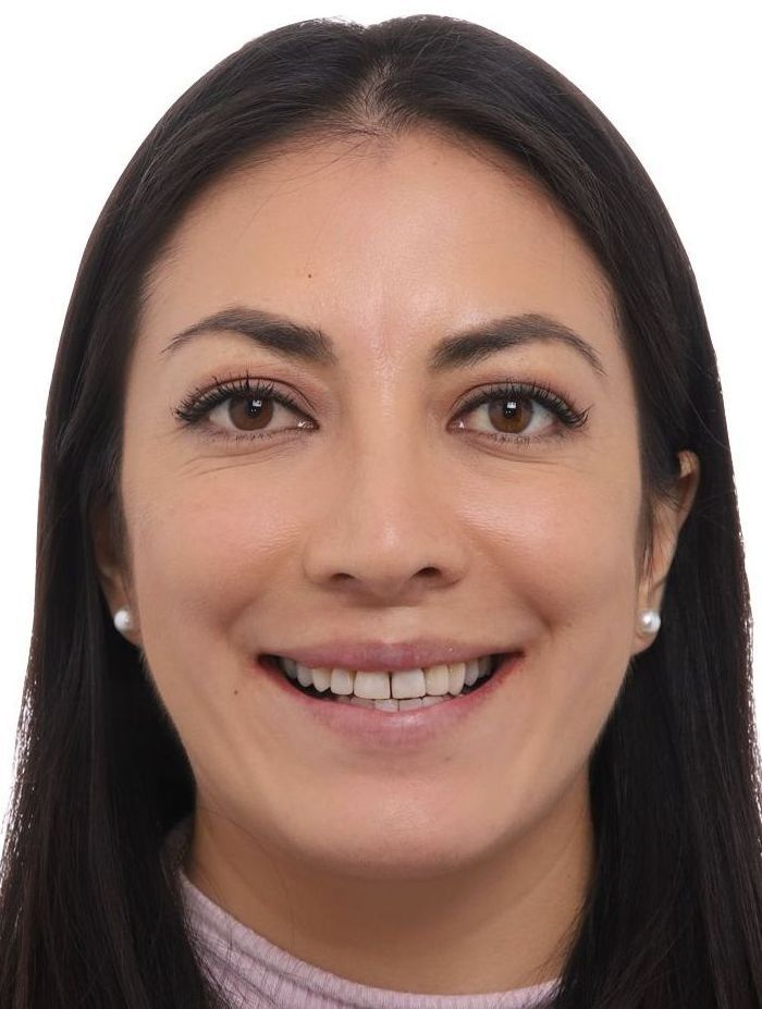 A woman with long dark hair is smiling for the camera.