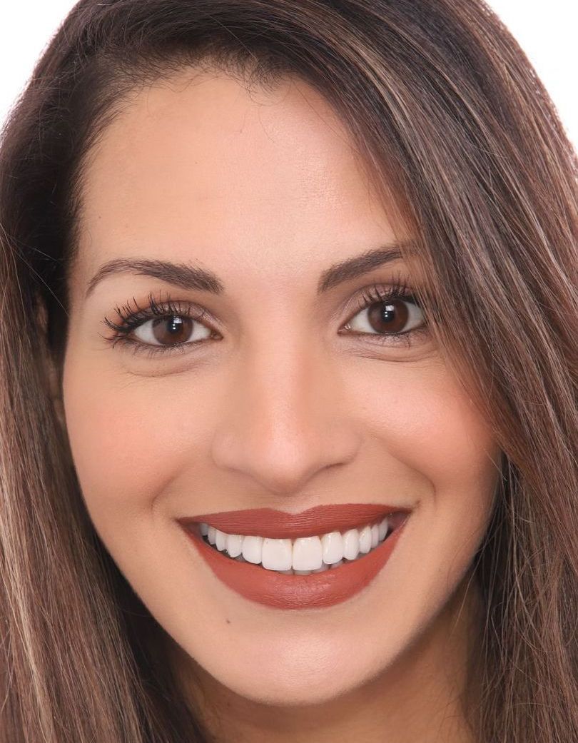 A close up of a woman 's face with a smile on her face