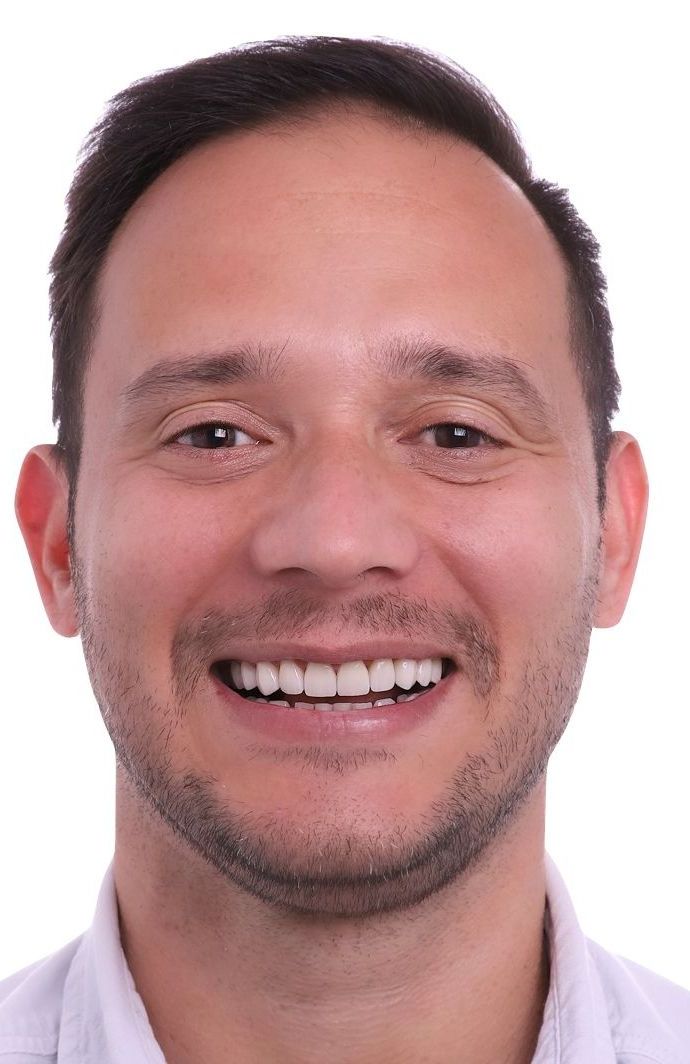 A man with a beard is smiling for the camera