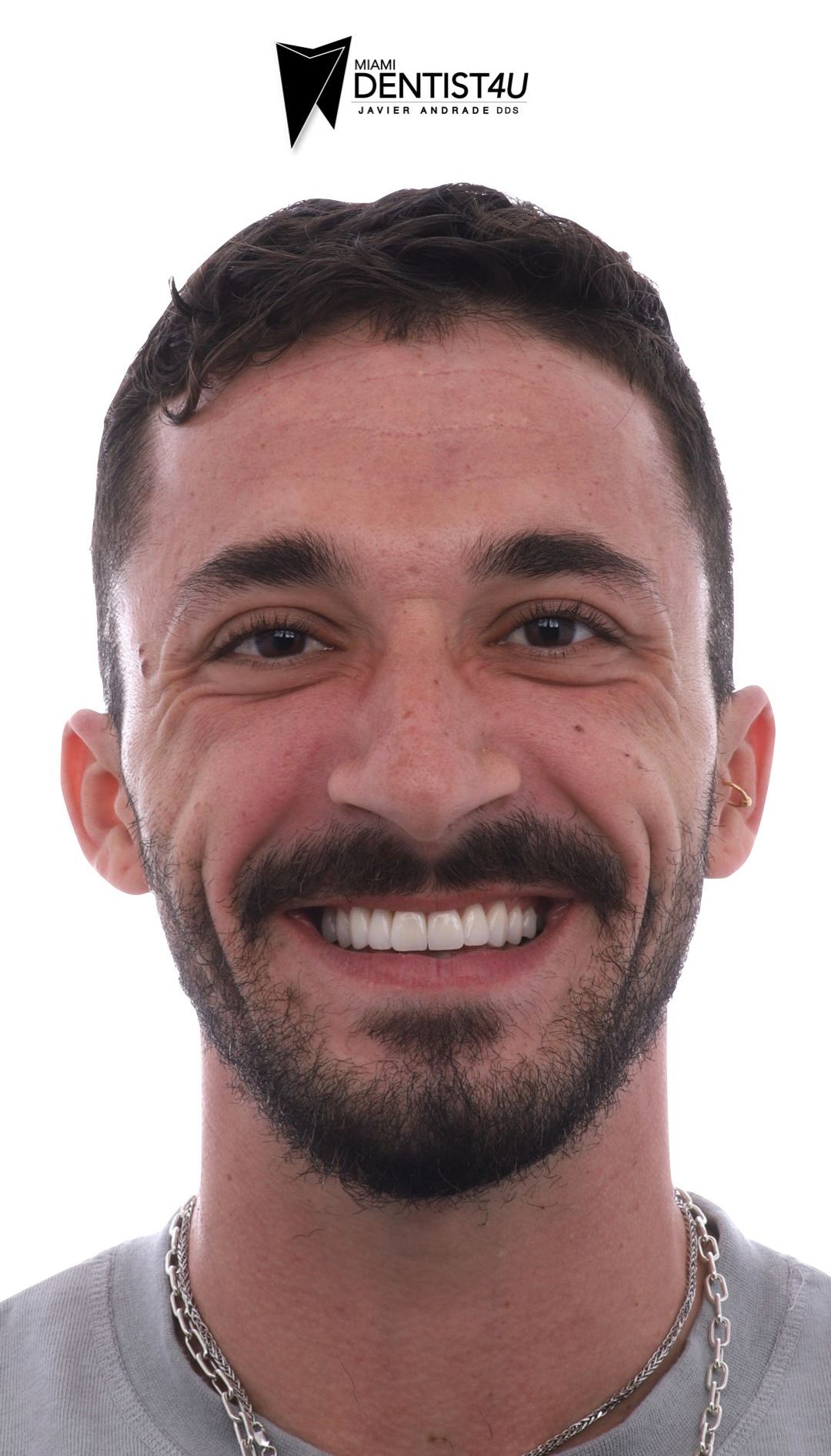 A man with a beard and mustache is smiling for the camera.