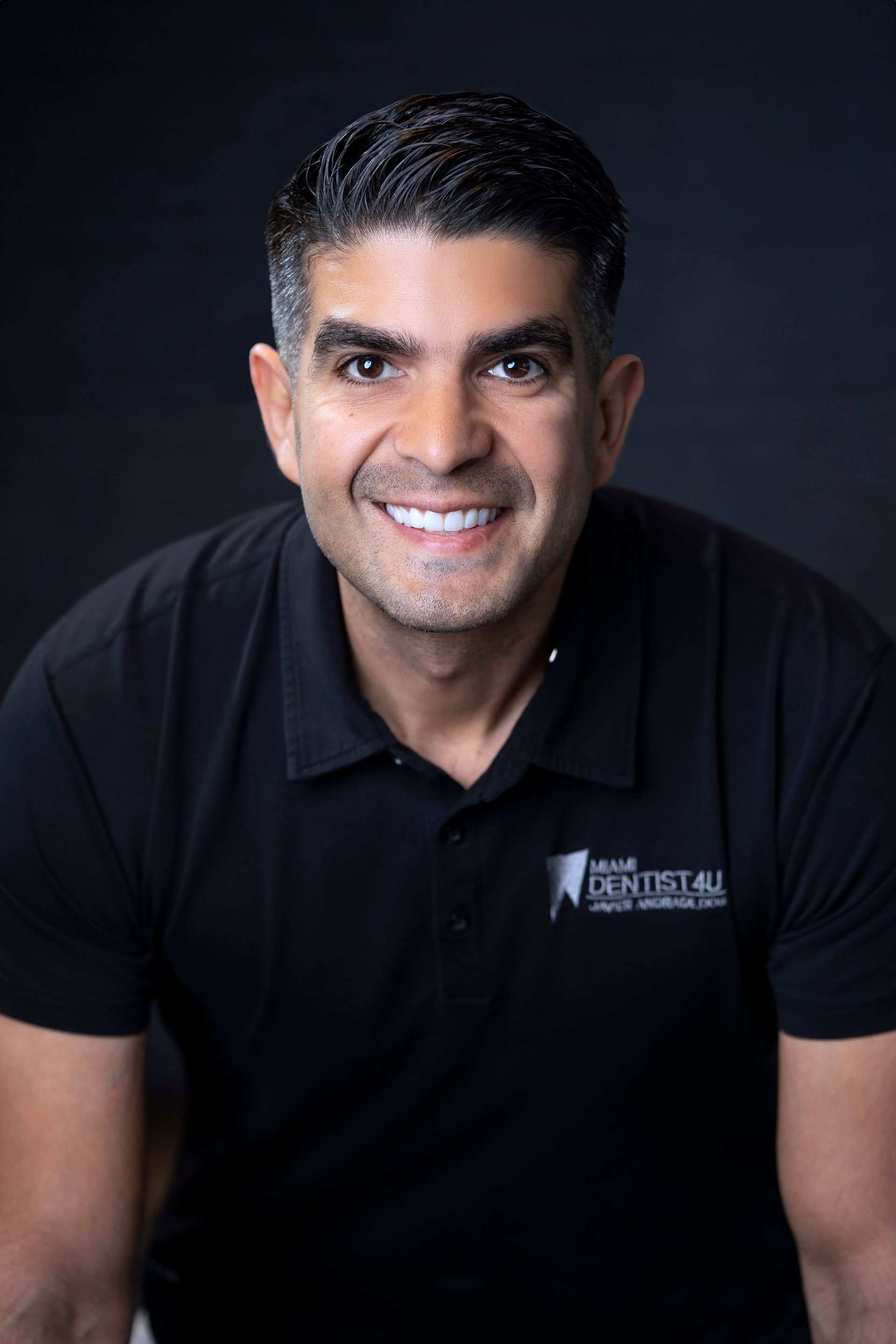 A man in a black shirt is smiling for the camera.