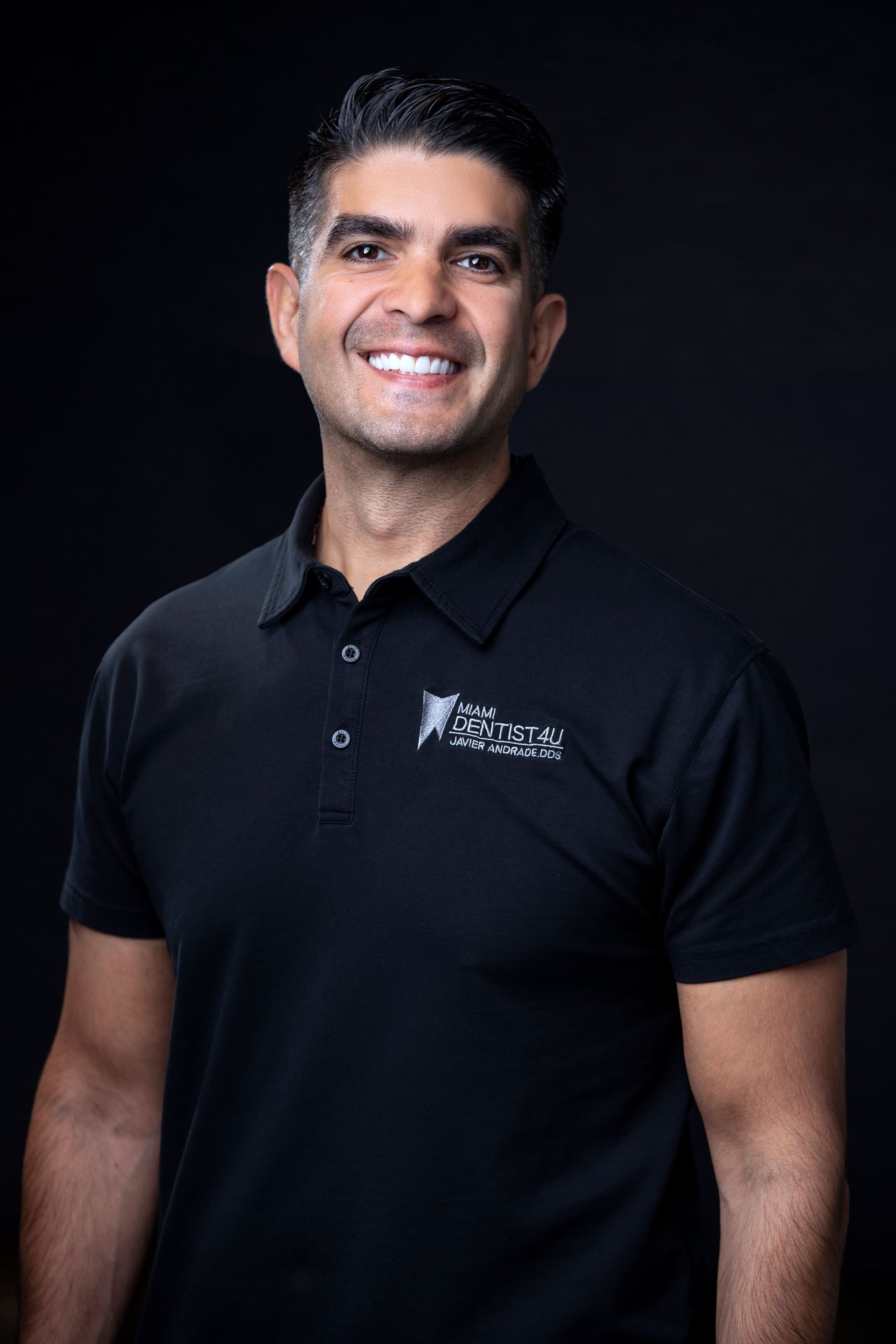 A man in a black shirt is smiling for the camera.