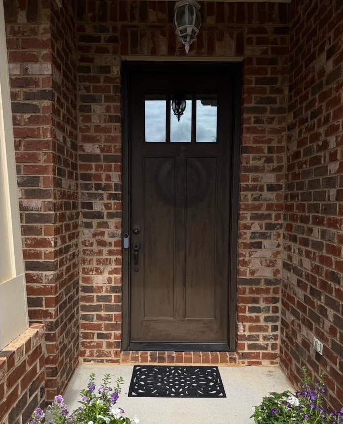 Brick fireplace with wooden mantel, decorative urns, and metal fire screen.
