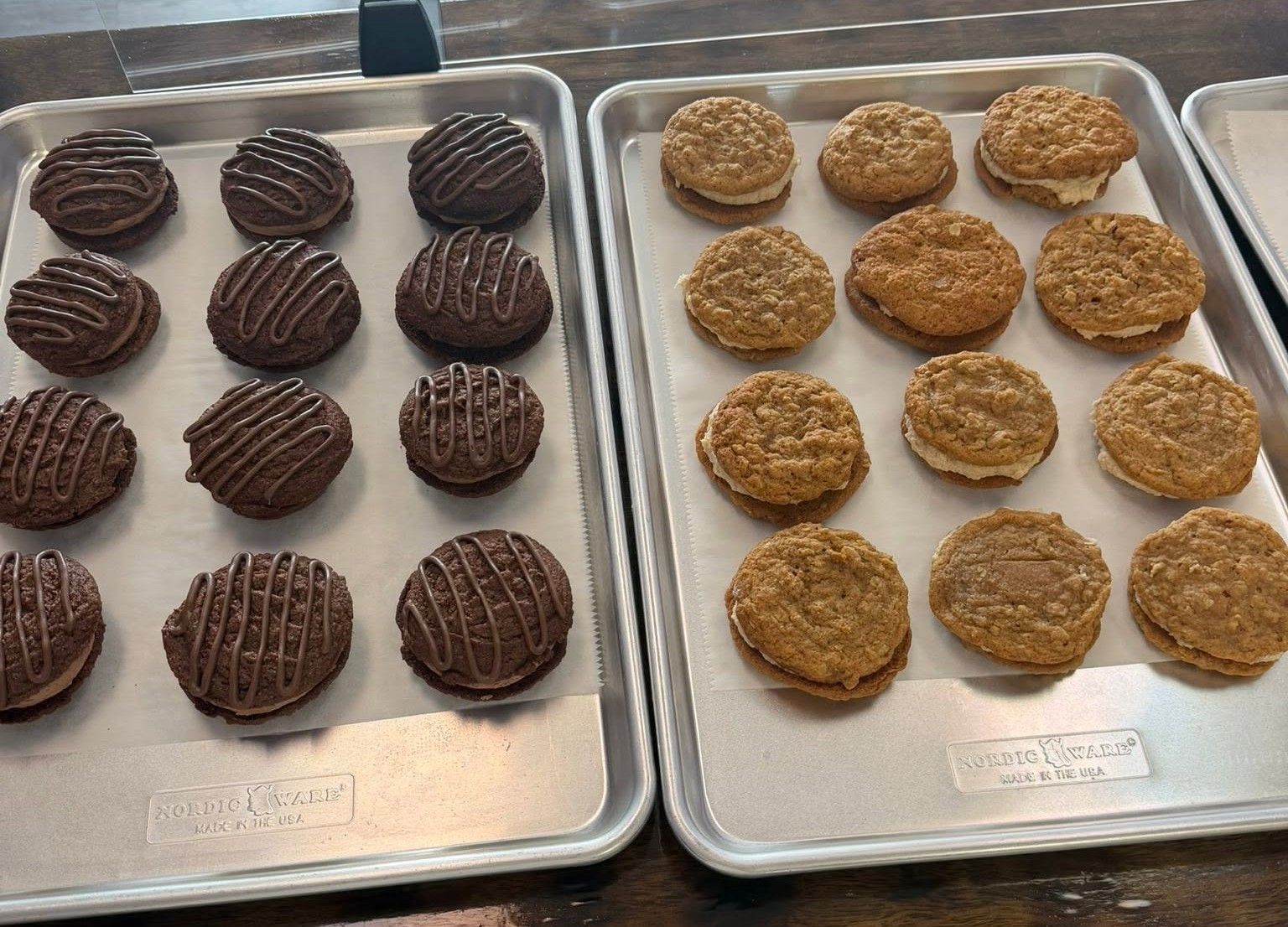 Two trays of assorted cookies, chocolate on the left and oatmeal on the right