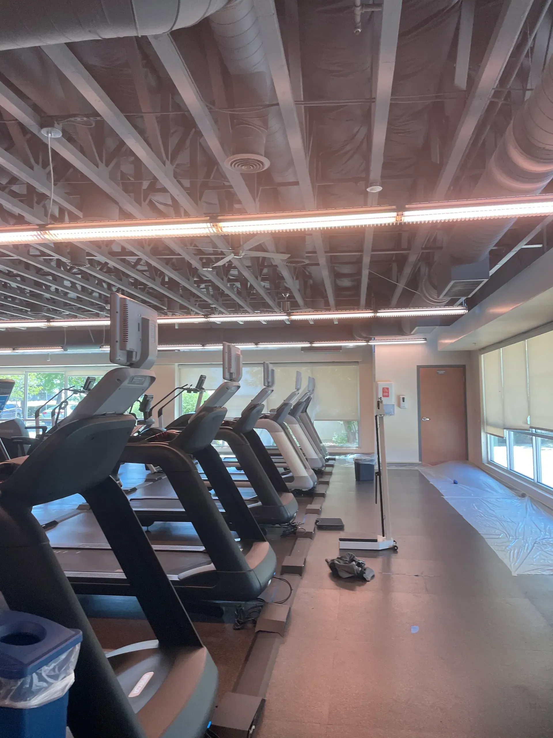A row of treadmills are lined up in a gym