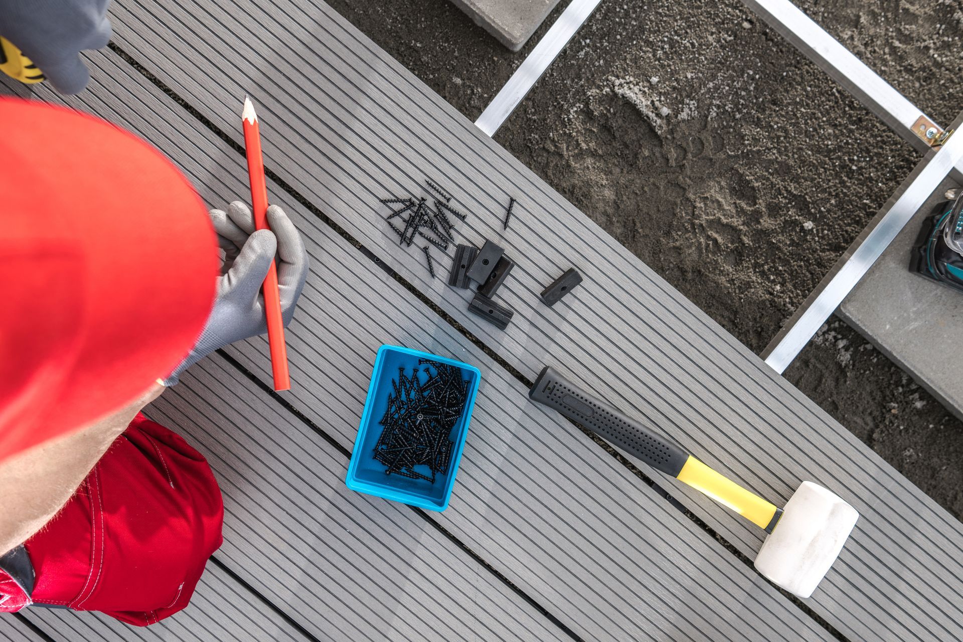 Deck Builder Laying composite decking with Tools and Fasteners